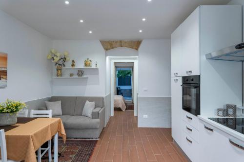 una cucina e un soggiorno con un tavolo e un divano di OLIVUZZA TOWER a Palermo