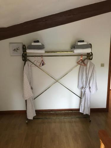 Cette chambre comprend des cintres et des peignoirs sur un mur. dans l'établissement Maison L’allee, à Lézignac-Durand