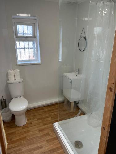 a white bathroom with a toilet and a shower at Windsor stays 1 in Liverpool