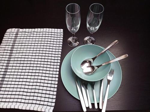 una mesa con un plato con una cuchara y dos copas de vino en The Yew Studio - Self contained one bed studio flat with parking, en Oxford