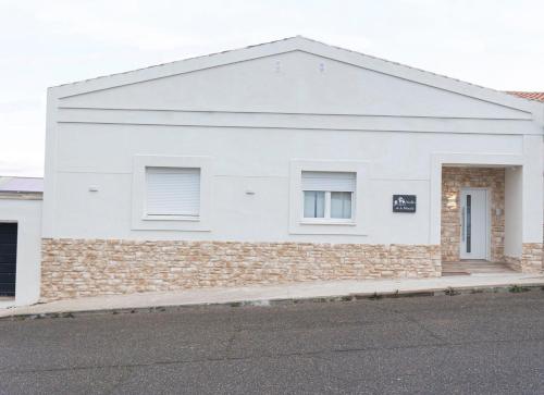 a white house with a brick wall at Huellas de la Mancha in Burguillos de Toledo