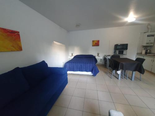 a bedroom with a bed and a table and a couch at La Mary in Mendoza