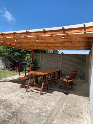 a wooden picnic table and chairs under a wooden pergola at Casa Mali in Azul