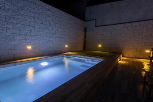 a swimming pool in a room with a brick wall at Huellas de la Mancha in Burguillos de Toledo