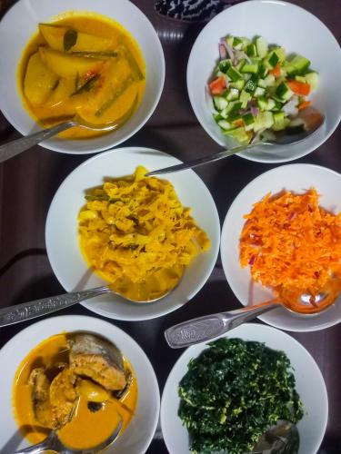 a table topped with plates of different types of food at Ella Happy View Homestay in Ella
