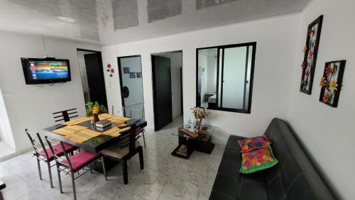 a living room with a dining room table and a couch at Apartamentos El Caudal, Villavicencio in Villavicencio