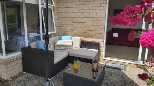 a porch with a couch and a coffee table at Mangawhai Heads apartment in Mangawhai