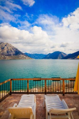 a balcony with two chairs and a view of the water at Villa Strp in Risan