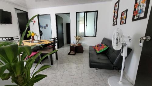 a living room with a black couch and a table at Apartamentos El Caudal, Villavicencio in Villavicencio