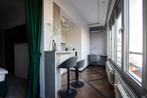 une chambre avec une chaise, une table et une fenêtre dans l'établissement Square 6, à Belgrade
