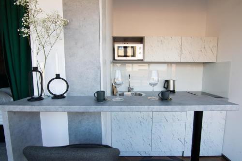 a kitchen with a counter with two glasses of wine at Square 6 in Belgrade