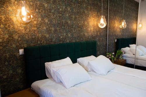 a bedroom with a green headboard and white pillows at Square 6 in Belgrade