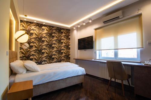 a bedroom with a bed and a desk and a window at Square 6 in Belgrade