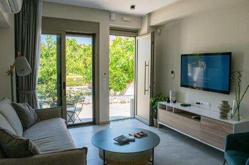 a living room with a couch and a tv at PANORMUS Luxury House in Panormos Rethymno