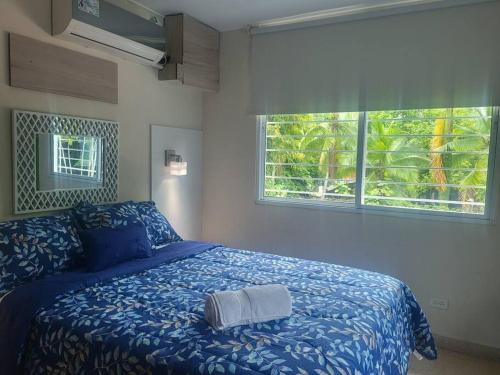 um quarto com uma cama azul e uma janela em R.504 Hermoso estudio, con cocina y baño privado. na Cidade do Panamá