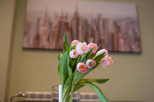 a glass vase filled with pink flowers on a table at Square 6 in Belgrade