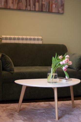 a coffee table with a vase of flowers on it at Square 6 in Belgrade