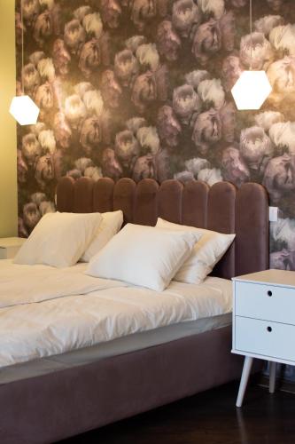 a bedroom with a bed with a floral wall at Square 6 in Belgrade