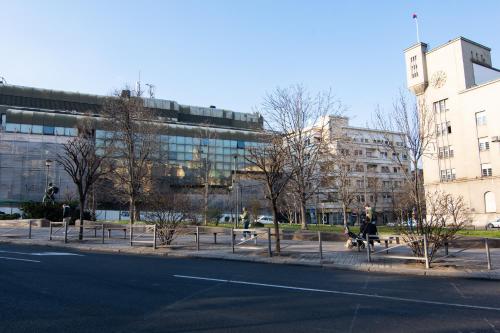 a city street with people sitting on benches in front of a building at Square 6 in Belgrade