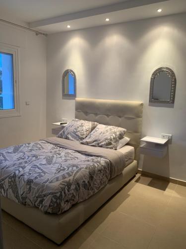 um quarto com uma cama com duas mesas e duas janelas em Appartement de standing Résidence Kariat Cabo em Cabo Negro