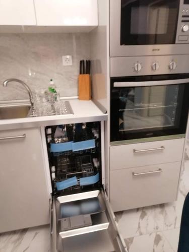 a kitchen with an open dishwasher next to a sink at Villa Casagrande in Kriopigi