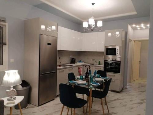 a kitchen with a table with chairs and a refrigerator at Villa Casagrande in Kriopigi