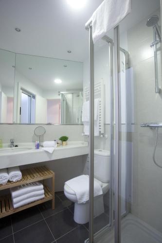 a bathroom with a toilet and a sink and a shower at Catedral Site by Como en Casa in Santiago de Compostela