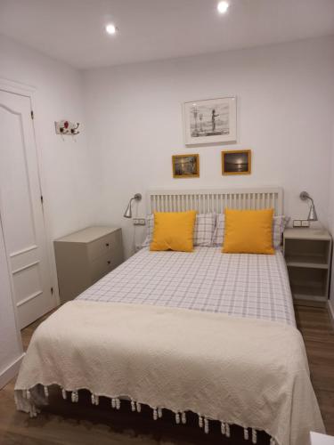1 dormitorio con 1 cama con 2 almohadas amarillas en Rosario 14 Cimavilla en Gijón