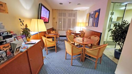 a dining room with tables and chairs in a room at Hotel Amadeus Dresden Neustadt in Dresden
