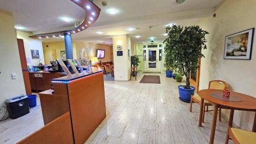 a lobby with a restaurant with a table and chairs at Hotel Amadeus Dresden Neustadt in Dresden