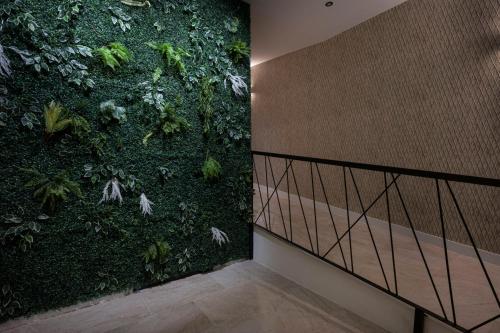a green wall with a staircase in a room at Huellas de la Mancha in Burguillos de Toledo