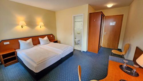 a hotel room with a bed and a bathroom at Hotel Amadeus Dresden Neustadt in Dresden