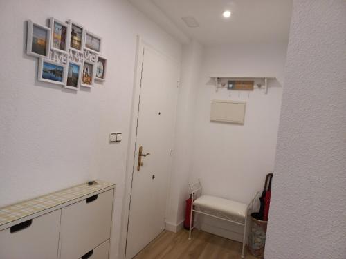 a white bathroom with a toilet and a door at Rosario 14 Cimavilla in Gijón