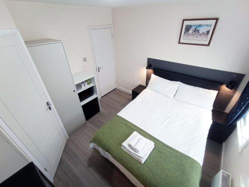 オックスフォードにあるThe Maple Studio - Self contained one bed studio flatの小さなベッドルーム(緑の毛布付きのベッド付)