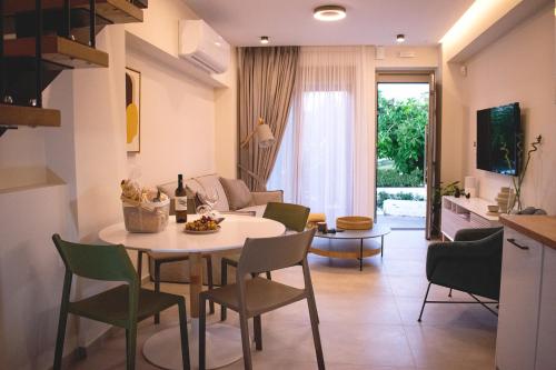 パノルモス・レティムノにあるPANORMUS Luxury Houseのキッチン、リビングルーム(テーブル、椅子付)