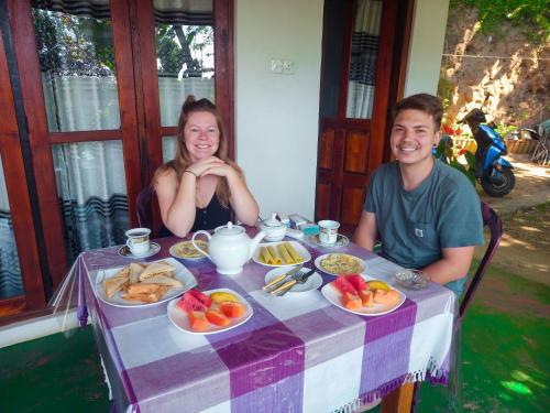 a man and woman sitting at a table with food at Ella Happy View Homestay in Ella
