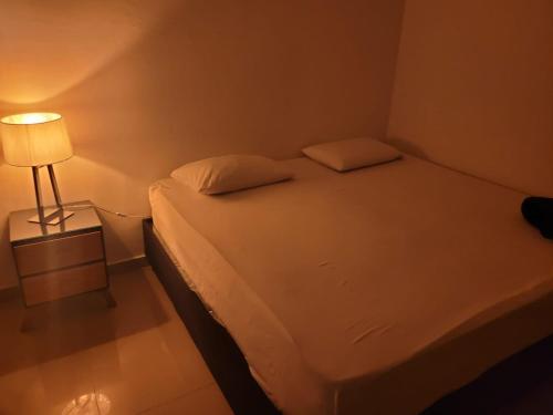 a small bedroom with a bed and a lamp at BOUTIQUE REAL in Barrancabermeja