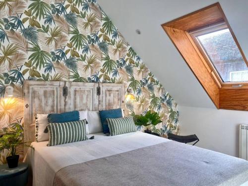 1 dormitorio con 1 cama grande y papel pintado tropical en El Ático de Vigo, en Vigo