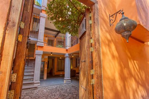 uma porta aberta para um edifício com uma parede em El Secreto em San Miguel de Allende