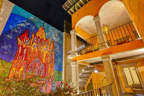 a large mural on the side of a building with stairs at El Secreto in San Miguel de Allende