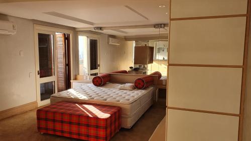 a living room with a bed and a kitchen at Flat Independência in Porto Alegre