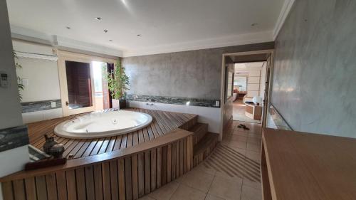 a large bathroom with a tub and a shower at Flat Independência in Porto Alegre