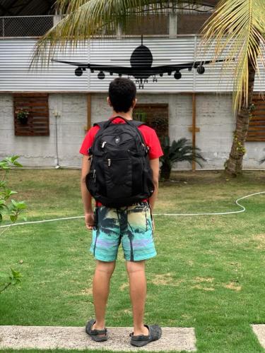 un garçon avec un sac à dos et un skateboard sur le dos dans l'établissement Quinta Alejandra, à Portoviejo
