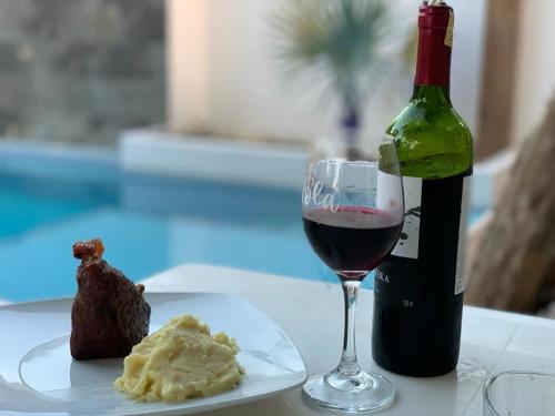 - un verre de vin rouge à côté d'une bouteille de vin dans l'établissement Quinta Alejandra, à Portoviejo