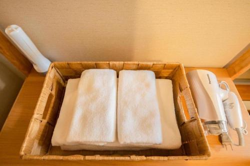 Una cesta con tres toallas en una mesa. en Bself Fuji Onsen Villa, en Fujiyoshida
