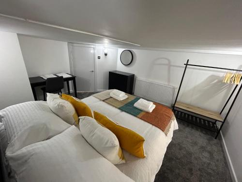 1 dormitorio con 1 cama blanca grande con almohadas amarillas en Airport Hideaway, en Mánchester