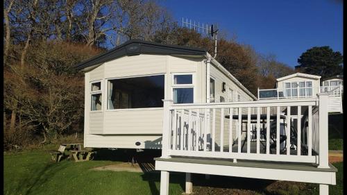 ein weißes Haus mit einer Veranda und einer Terrasse in der Unterkunft Classy caravan with ample space in Bembridge