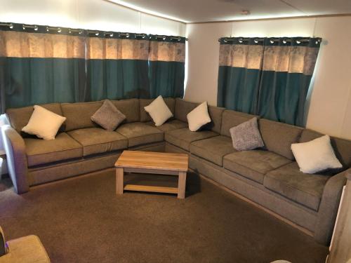 a living room with a couch and a coffee table at Classy caravan with ample space in Bembridge