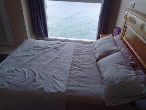 a bed in a room with a large window at Goldenbeachhouse in Mirleft