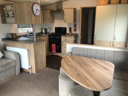 a small kitchen with a wooden table in a caravan at Classy caravan with ample space in Bembridge
